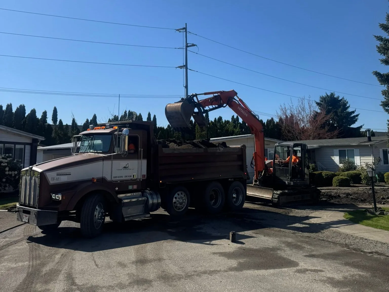 Excavator loading a dump truck, demolition