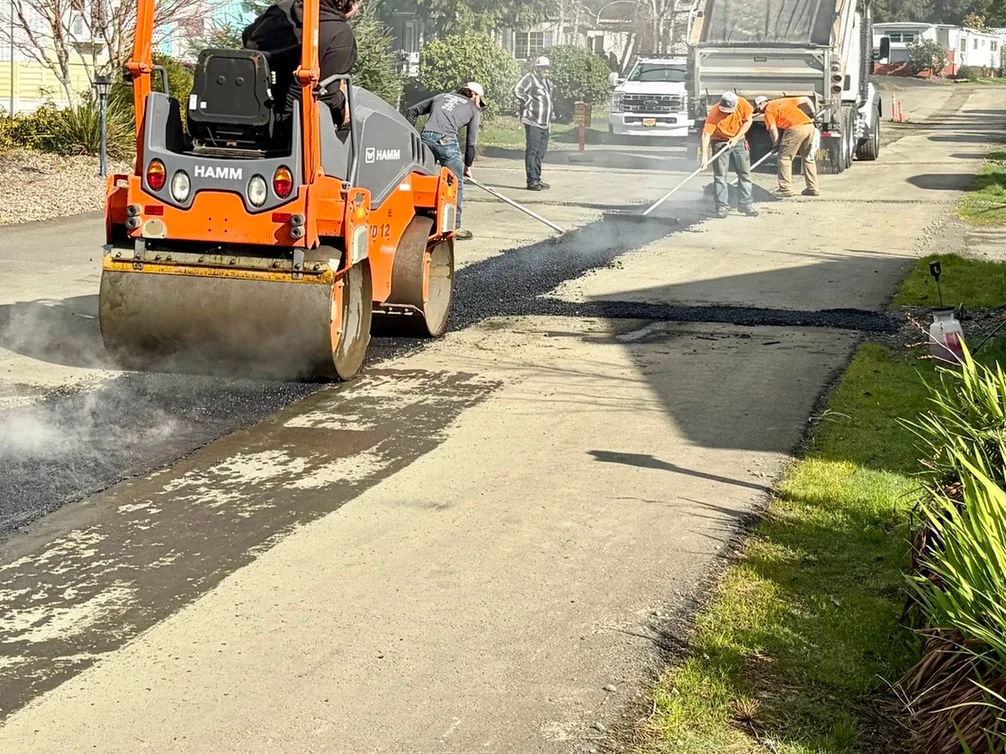 Roller compacting a fresh asphalt surface, driveways and access roads