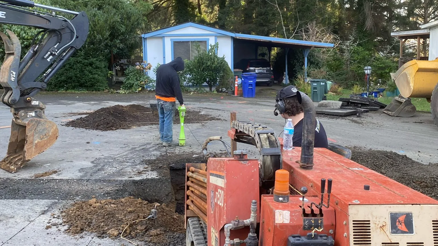 Directional drill rig and crew at a bore beside a street, directional drilling