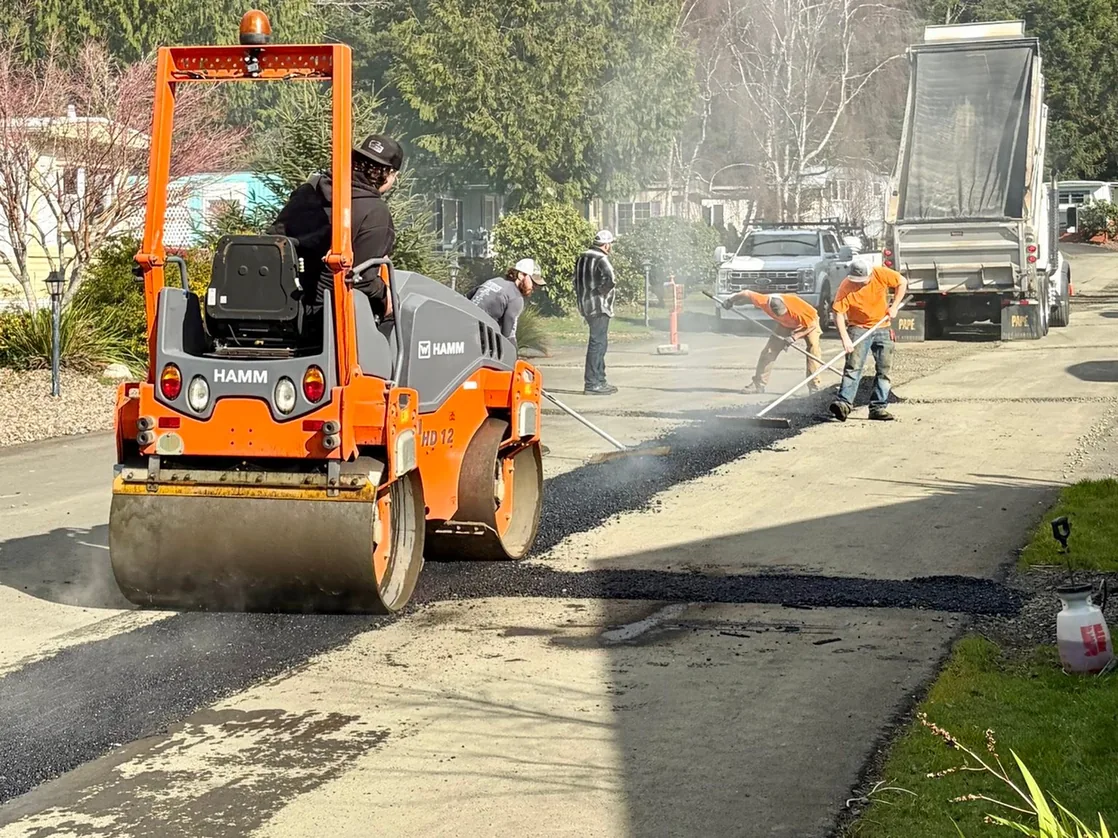 Roller compacting fresh asphalt on a road, road street construction