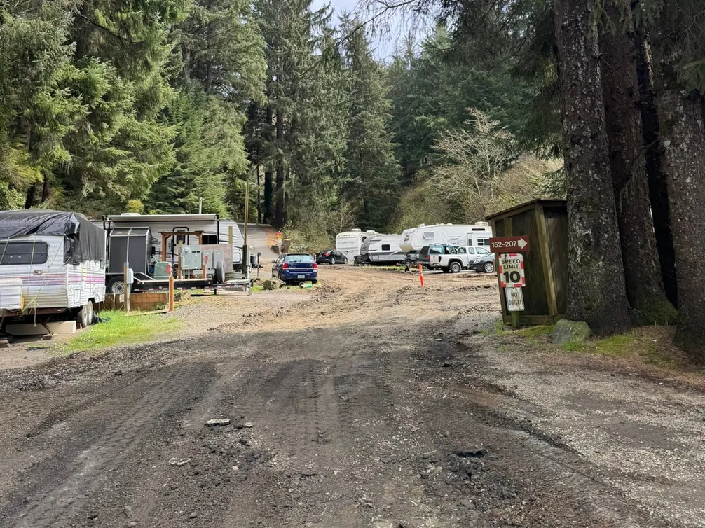 Dirt road bed through a park with trailers parked beside it, subdivision development