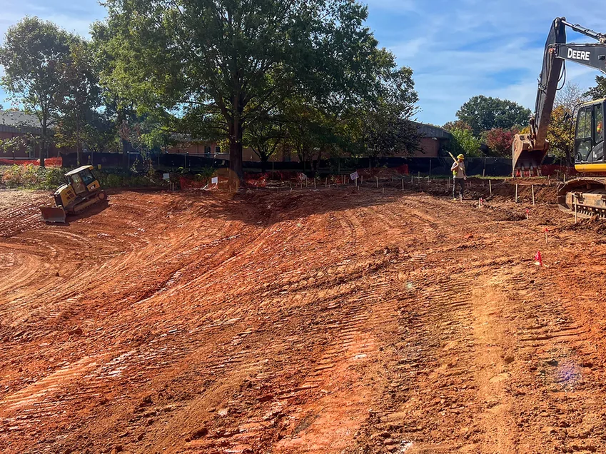 Excavator and small dozer mass grading a staked site, subdivision development